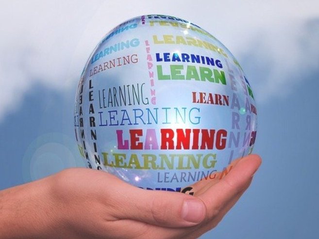 Das Bild zeigt eine Hand in der sich ein sehr großer Wassertropfen befindet, auf dem mehrfach die Worte Learn und Learning stehen.