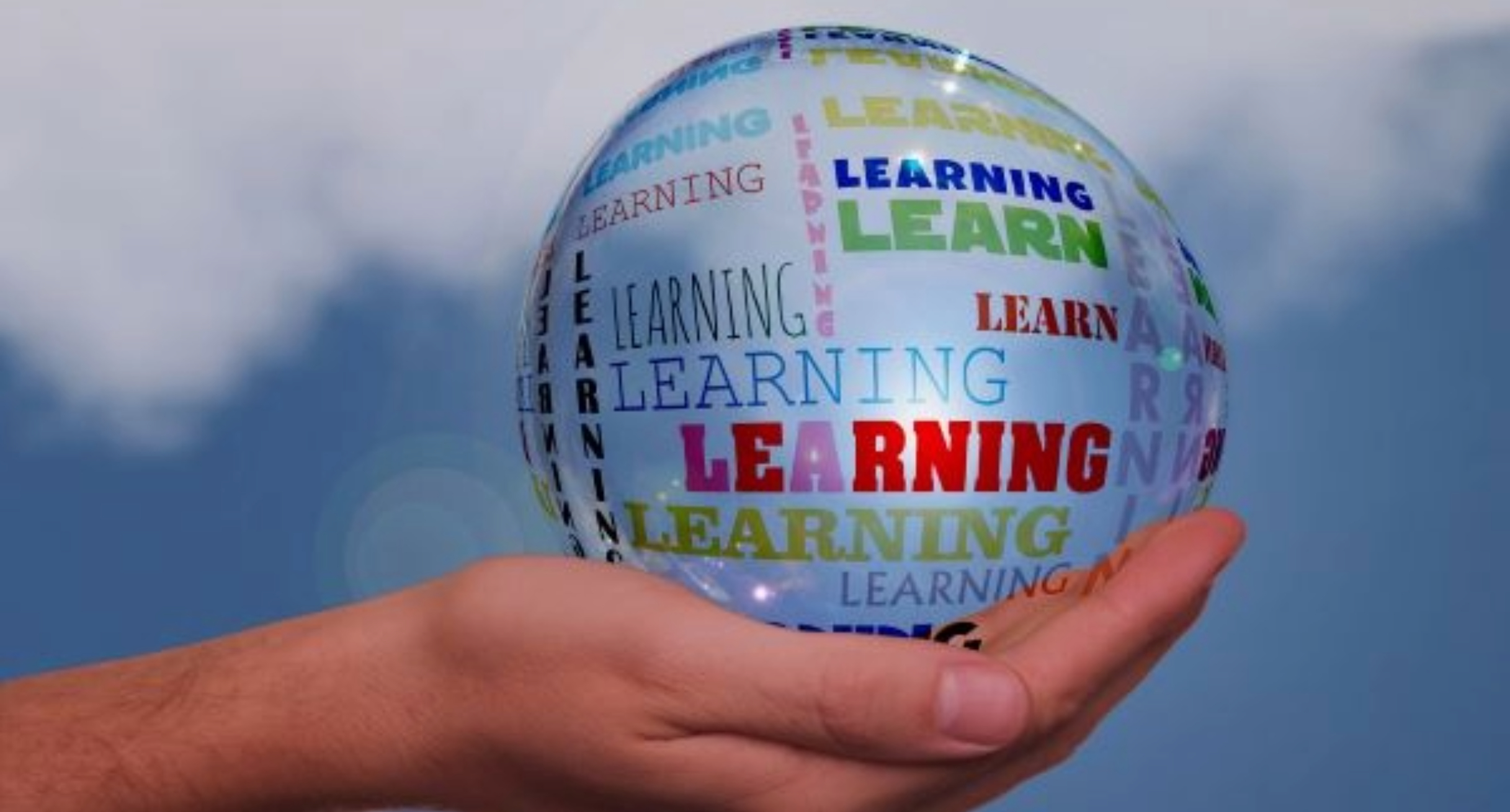 Das Bild zeigt eine Hand in der sich ein sehr großer Wassertropfen befindet, auf dem mehrfach die Worte Learn und Learning stehen.