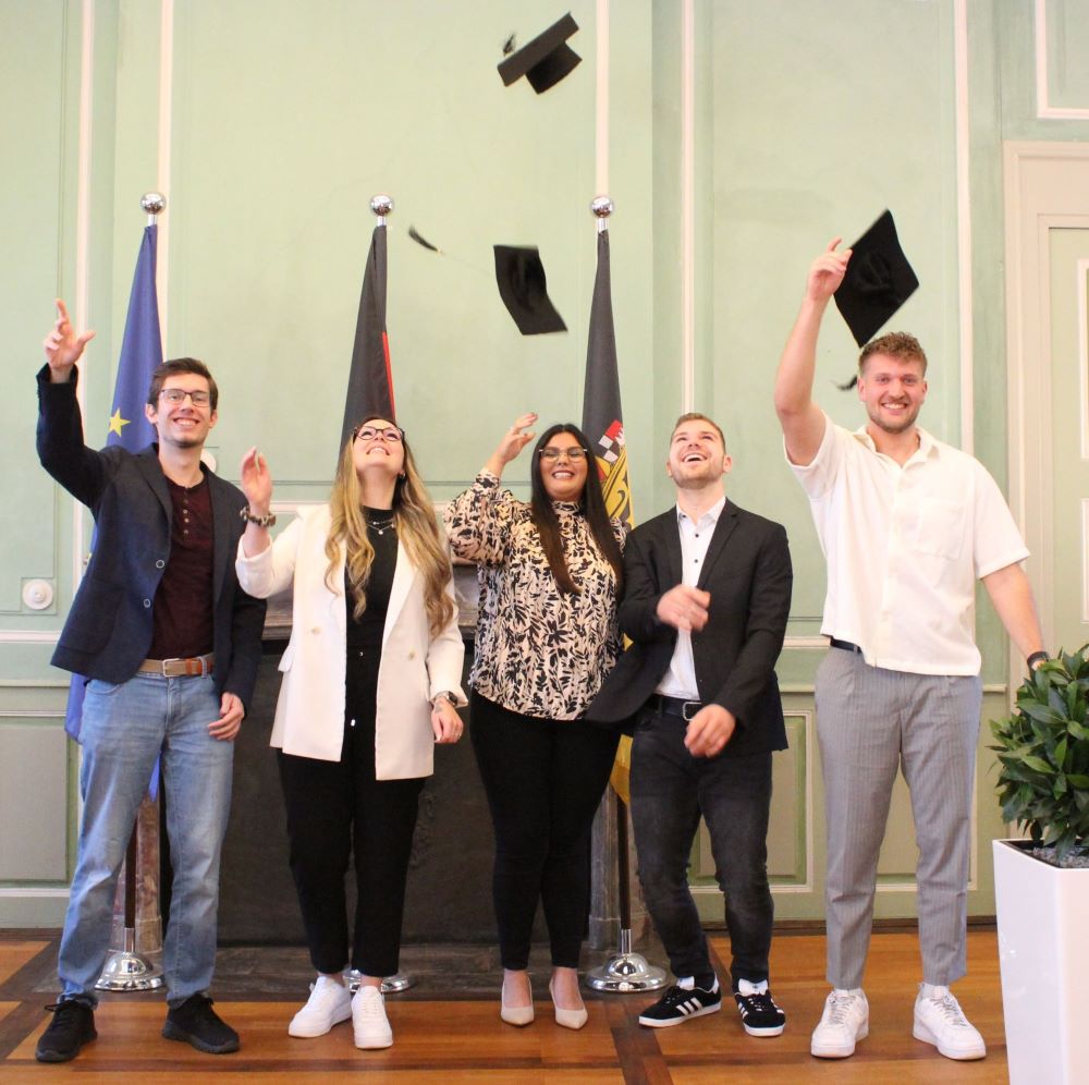 Das Bild zeigt die zur Bachelorfeier 2024 erschienenen fünf Absolventinnen und Absolventen, die ihre 